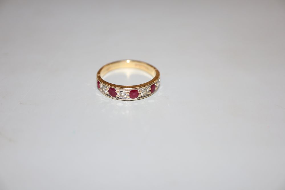 A modern 18ct gold, ruby and diamond set nine stone half hoop ring, size M, gross 3.2 grams.